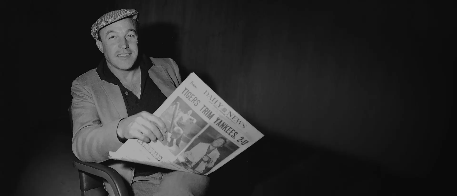 Gene Kelly holding a newspaper